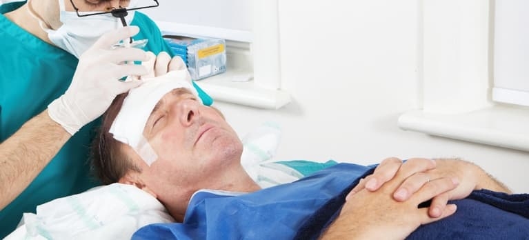 Paciente se submetendo a uma cirurgia de transplante capilar com um cirurgião